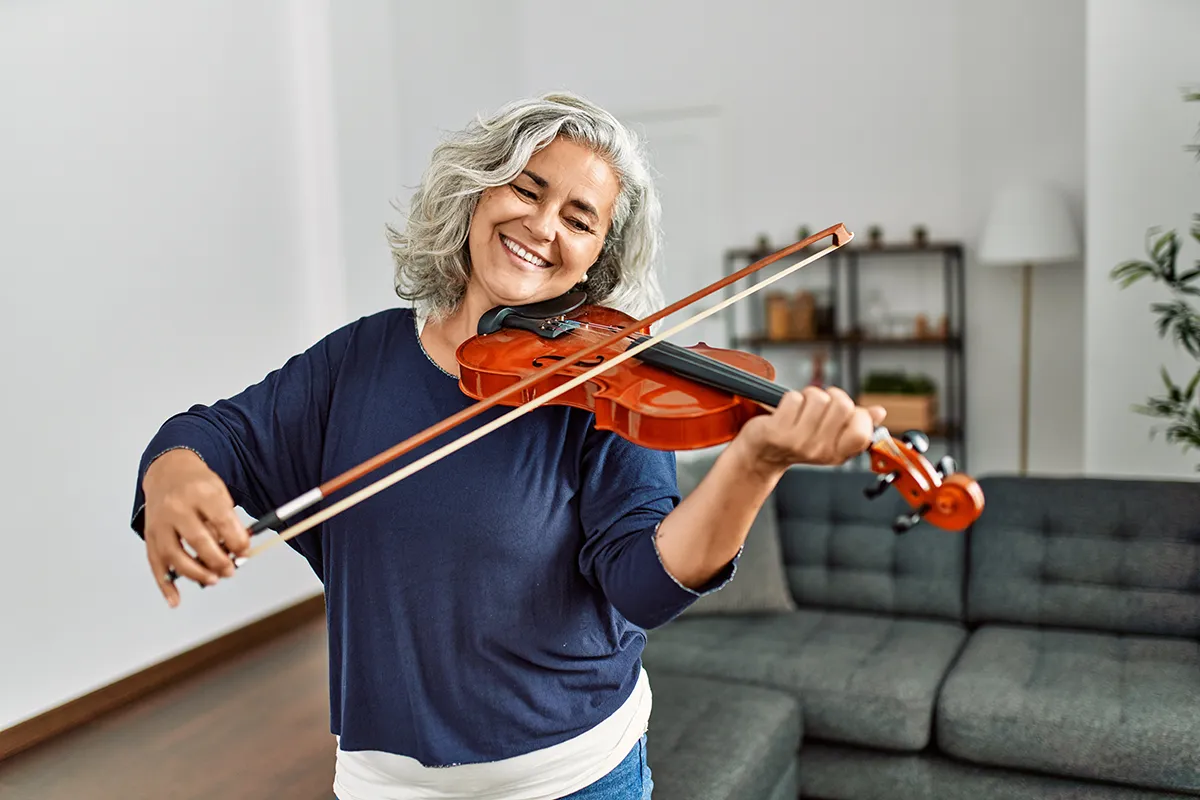 Older lady learning to play the violin.